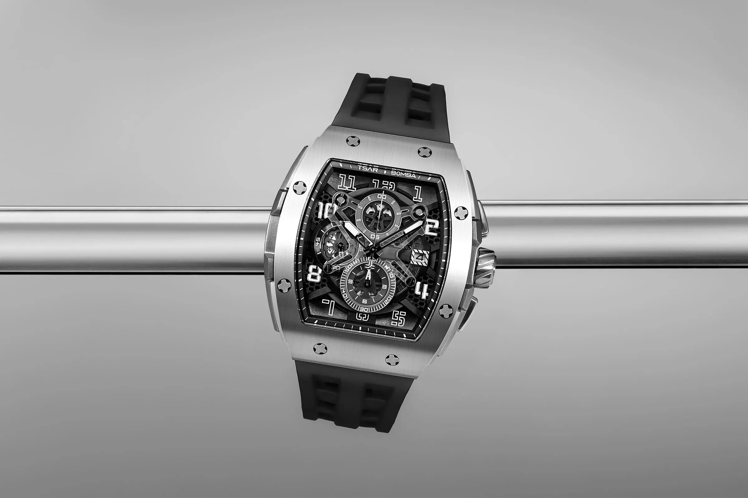 The TSAR BOMBA Elemental TB8211Q Stainless Steel Tonneau Chronograph Watch. Features a stainless steel case and a Seiko quartz movement. The multi-layered skeleton dial combines date display and chronograph functions. A 1/20th-second chronograph subdial is located at 12 o'clock, the date display at 3 o'clock, the hour/minute chronograph subdial at 6 o'clock, and the chronograph seconds subdial at 9 o'clock.-- Scene display