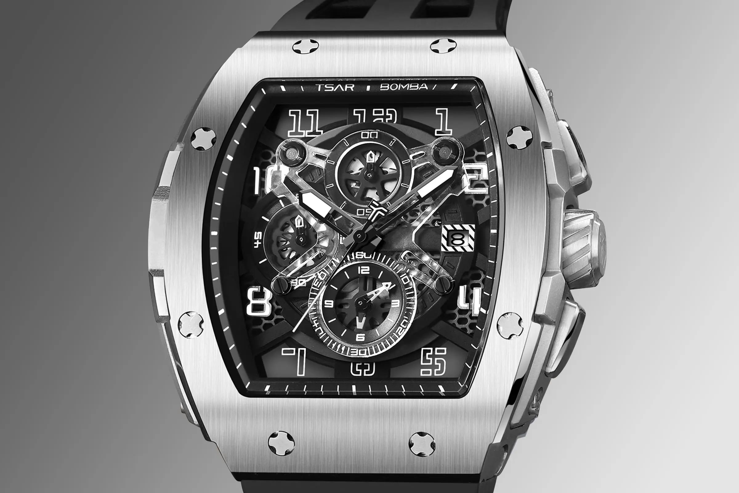 The TSAR BOMBA Elemental TB8211Q Stainless Steel Tonneau Chronograph Watch. Features a stainless steel case and a Seiko quartz movement. The multi-layered skeleton dial combines date display and chronograph functions. A 1/20th-second chronograph subdial is located at 12 o'clock, the date display at 3 o'clock, the hour/minute chronograph subdial at 6 o'clock, and the chronograph seconds subdial at 9 o'clock.-- dial-dissplay