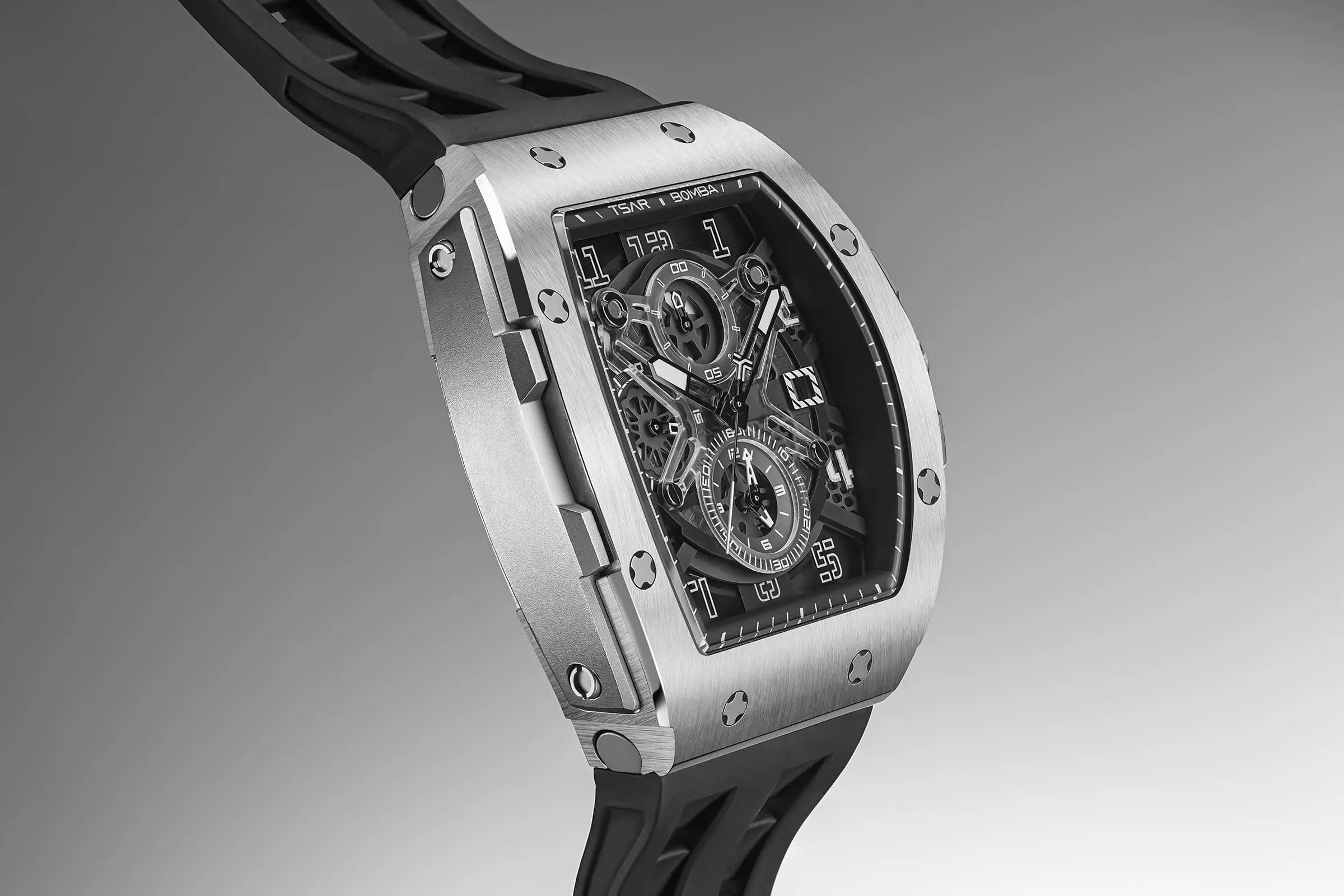 The TSAR BOMBA Elemental TB8211Q Stainless Steel Tonneau Chronograph Watch. Features a stainless steel case and a Seiko quartz movement. The multi-layered skeleton dial combines date display and chronograph functions. A 1/20th-second chronograph subdial is located at 12 o'clock, the date display at 3 o'clock, the hour/minute chronograph subdial at 6 o'clock, and the chronograph seconds subdial at 9 o'clock.-- dial-Side view