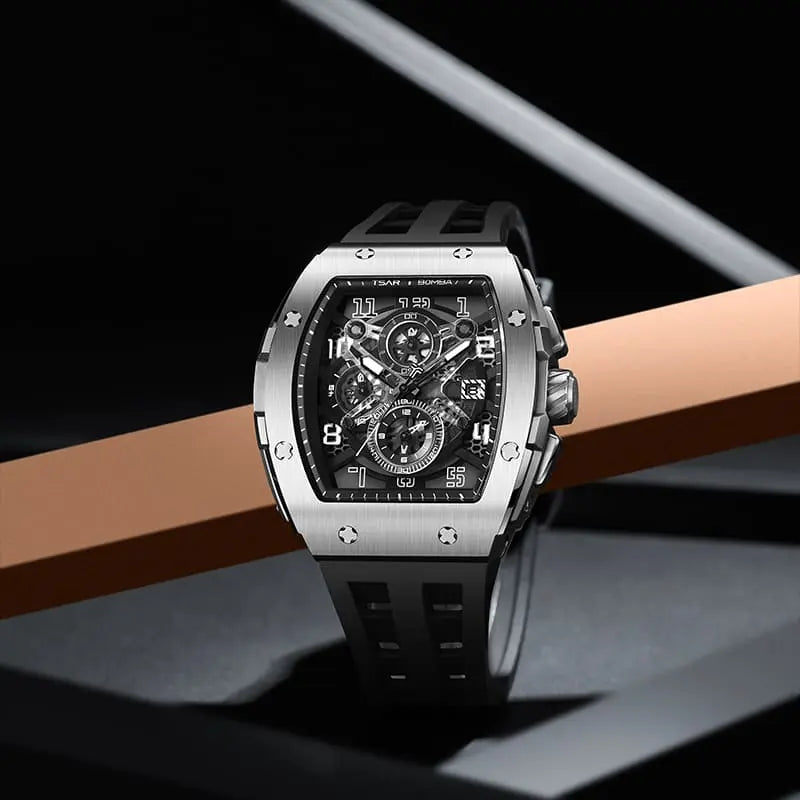 The TSAR BOMBA Elemental TB8211Q Stainless Steel Tonneau Chronograph Watch. Features a stainless steel case and a Seiko quartz movement. The multi-layered skeleton dial combines date display and chronograph functions. A 1/20th-second chronograph subdial is located at 12 o'clock, the date display at 3 o'clock, the hour/minute chronograph subdial at 6 o'clock, and the chronograph seconds subdial at 9 o'clock.-- Scene display