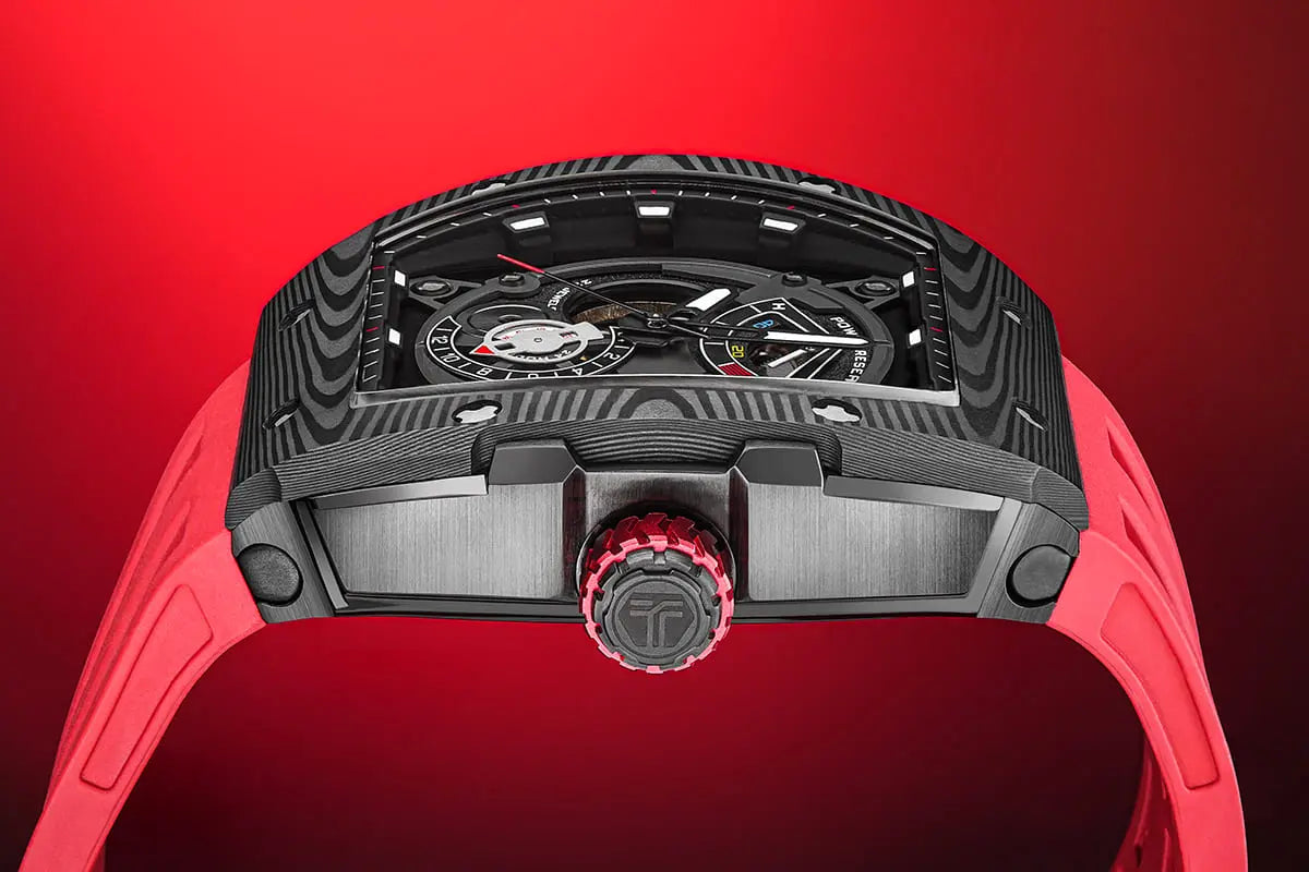 The TSAR BOMBA elemental TB8210CF automatic tourbillon tonneau-shaped watch features a carbon fiber bezel and a stainless steel case, powered by a Seiko Epson automatic movement. The tonneau-shaped case is complemented by a skeletonized dial and power reserve indicator. --Side view