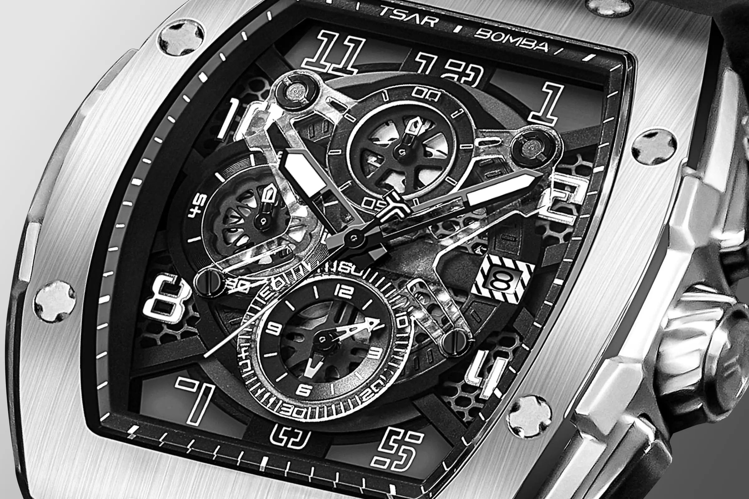 The TSAR BOMBA Elemental TB8211Q Stainless Steel Tonneau Chronograph Watch. Features a stainless steel case and a Seiko quartz movement. The multi-layered skeleton dial combines date display and chronograph functions. A 1/20th-second chronograph subdial is located at 12 o'clock, the date display at 3 o'clock, the hour/minute chronograph subdial at 6 o'clock, and the chronograph seconds subdial at 9 o'clock.--dial-display