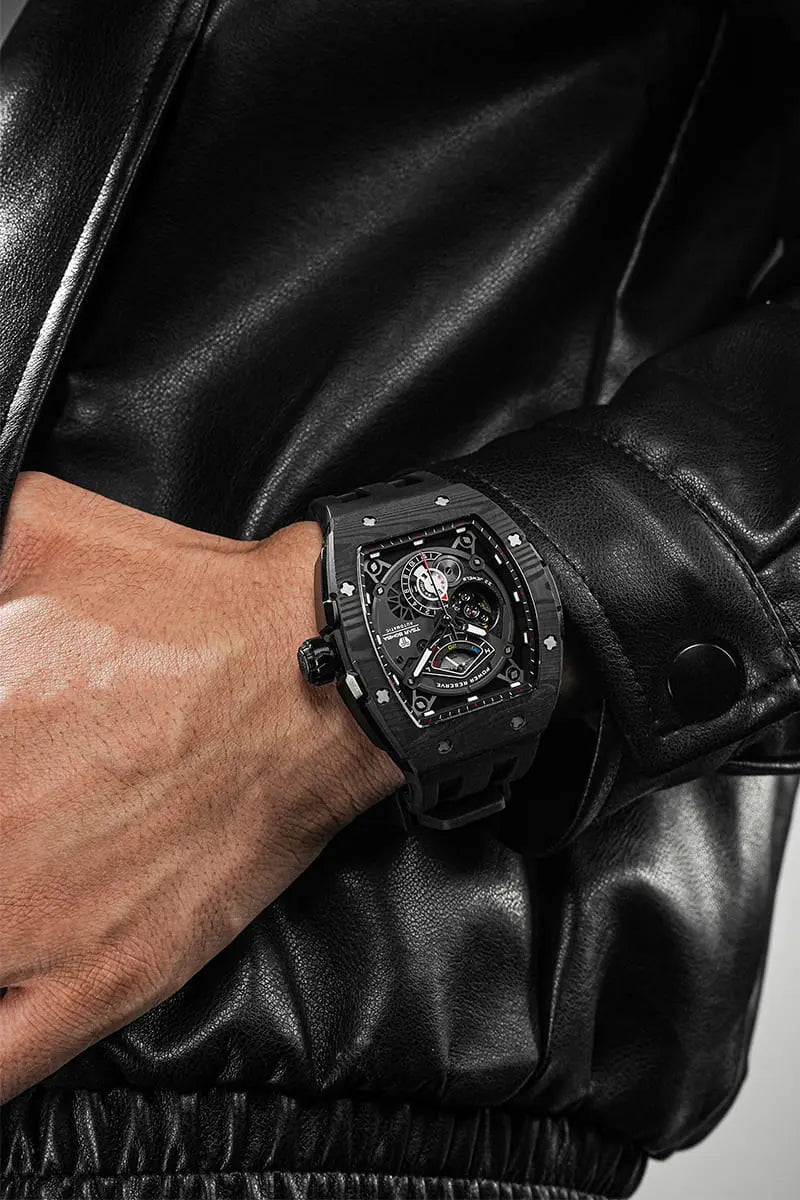 The TSAR BOMBA elemental TB8210CF automatic tourbillon tonneau-shaped watch features a carbon fiber bezel and a stainless steel case, powered by a Seiko Epson automatic movement. The tonneau-shaped case is complemented by a skeletonized dial and power reserve indicator. --Model wearing display