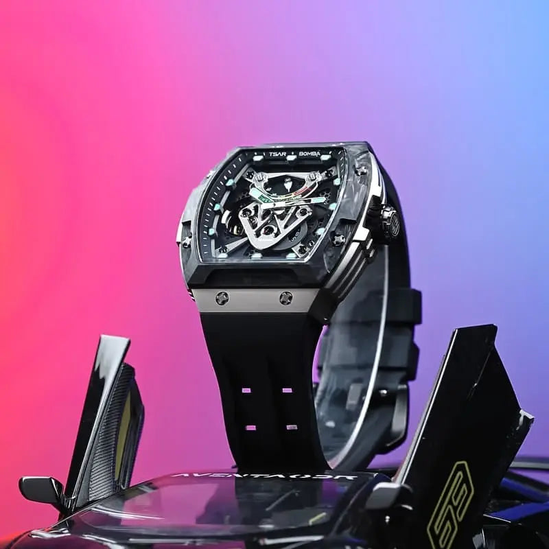 TSAR BOMBA tonneau skeleton watch displayed above a black supercar model, featuring a dark case, silver side panels, a black strap, and turquoise dial accents against a pink and blue background.