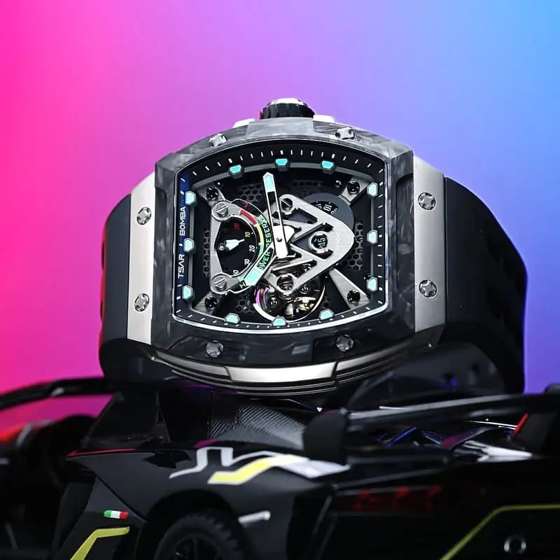 TSAR BOMBA tonneau skeleton watch displayed above a black supercar model, featuring a dark case, silver side panels, a black strap, and turquoise dial accents against a pink and blue background.