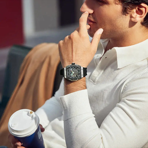 TSAR BOMBA TB8216 limited-edition tonneau watch, Model wearing and display, featuring a carbon fiber bezel and titanium case and black interchangeable strap. The power reserve indicator is at 12 o’clock, and the tourbillon is at 9 o’clock.--