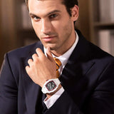 A man wearing a white TSAR BOMBA tonneau skeleton dila men watch with a white strap and white ceramic bezel. 