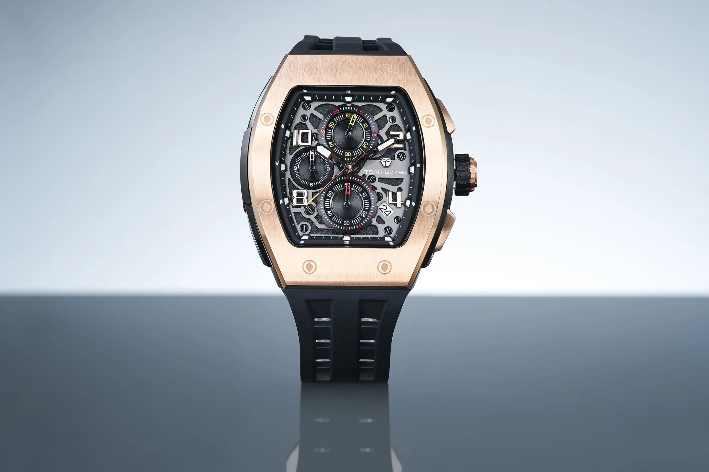 The TSAR BOMBA Elemental TB8224Q stainless steel tonneau quartz watch.Golden bezel and black strap.  The Multifunction dial design, the multifunction dial features a chronograph minute sub-dial at the 12 o'clock position, a date display between the 4 and 5 o'clock positions, a seconds sub-dial at the 6 o'clock position, and an hour chronograph sub-dial at the 9 o'clock position. --Front view And reflections.