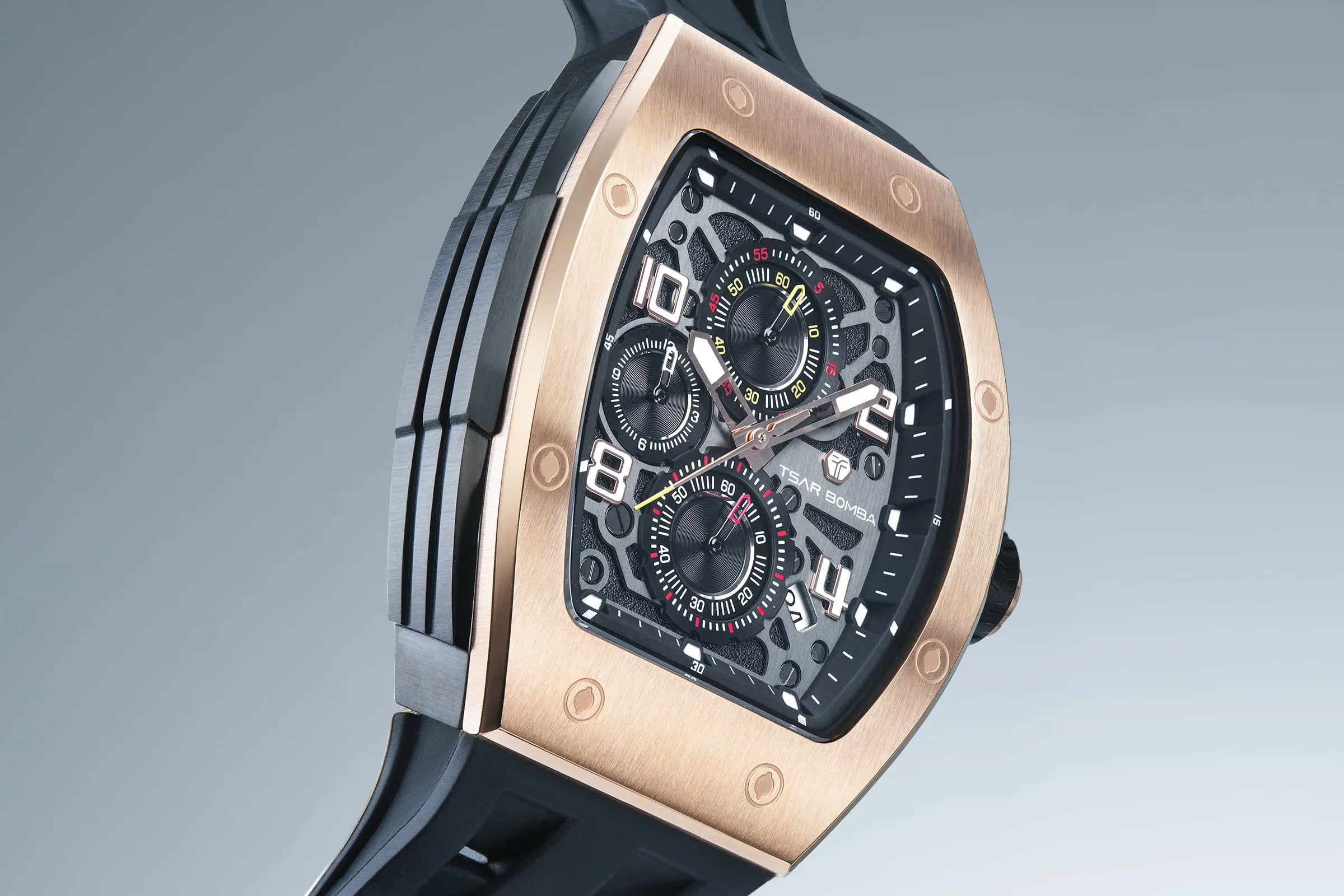 The TSAR BOMBA Elemental TB8224Q stainless steel tonneau quartz watch.Golden bezel and black strap.  The Multifunction dial design, the multifunction dial features a chronograph minute sub-dial at the 12 o'clock position, a date display between the 4 and 5 o'clock positions, a seconds sub-dial at the 6 o'clock position, and an hour chronograph sub-dial at the 9 o'clock position. --Right-three-quarter-view