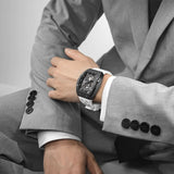 The TSAR BOMBA elemental TB8210CF automatic tourbillon tonneau-shaped watch features a carbon fiber bezel and a stainless steel case, powered by a Seiko Epson automatic movement. The tonneau-shaped case is paired with a skeletonized dial and a power reserve indicator.--Model wearing display