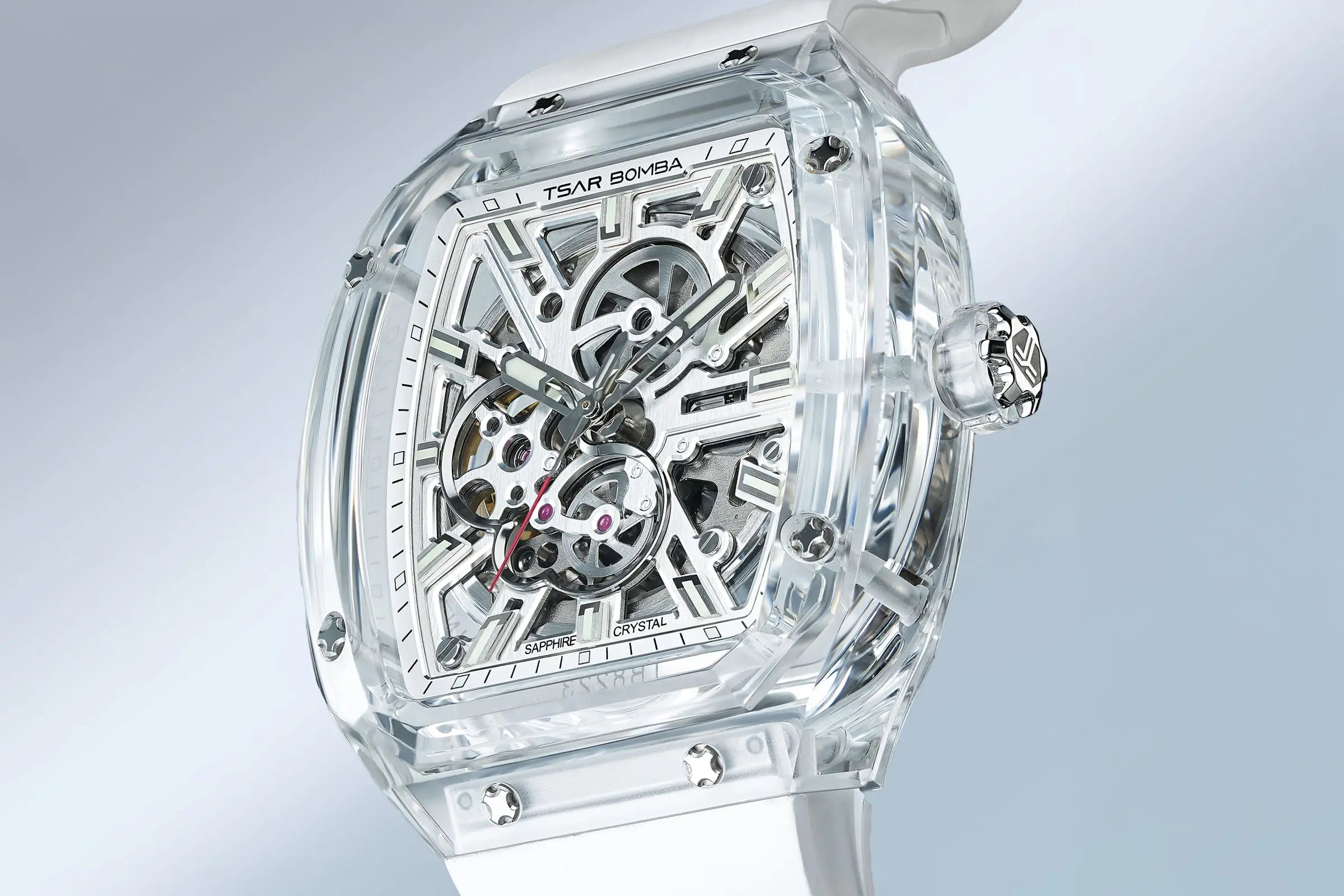 TSAR BOMBA Light Matter TB8223 Transparent Men's Watch. This watch features a TSAR BOMBA Chronite® case, allowing for quick and easy strap changes without tools. It is powered by a Japanese automatic movement with a flying tourbillon at 9 o'clock. The TB8223 includes a Grade A luminous coating, a scratch-resistant sapphire crystal, and a replaceable fluoroelastomer strap. It is water-resistant to 30 meters (3 ATM). white strap--dial-display